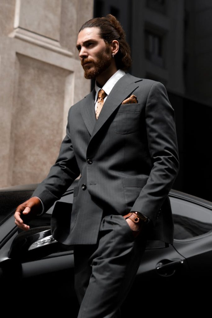 pexels photo 15654407 Sophisticated businessman in suit walking past a luxury sportscar in a city setting.